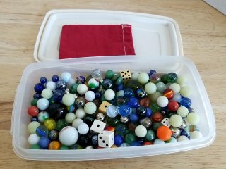 Marbles and Dice in Plastic Container