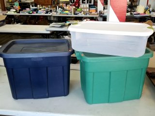 Three plastic storage bins